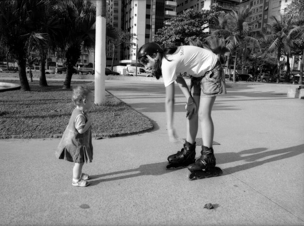 Teenager playing with baby girl while standing on street