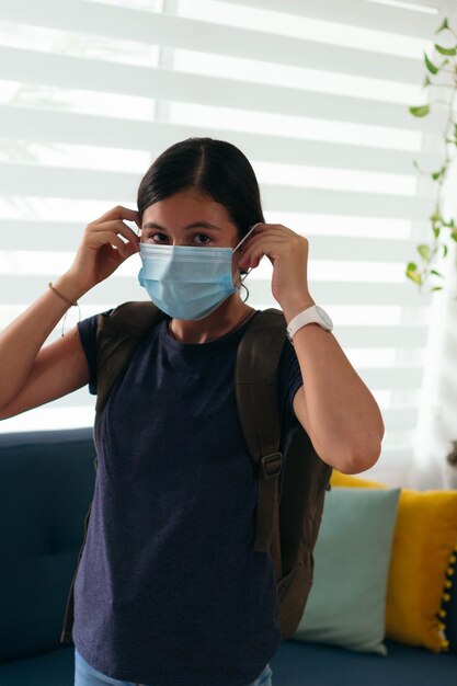 Teenager Putting On Protective Mask