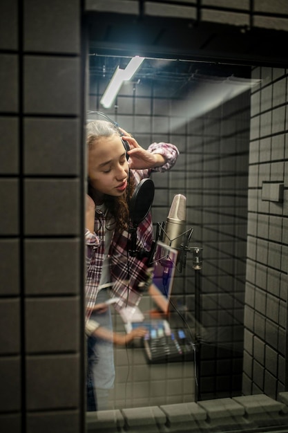 Teenager recording a song in the studio