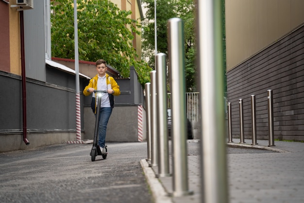 L'adolescente cavalca su uno scooter elettrico lungo la strada della città