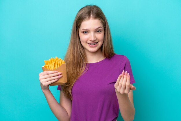 青の背景に分離されたフライド ポテトをキャッチ 10 代のロシアの女の子