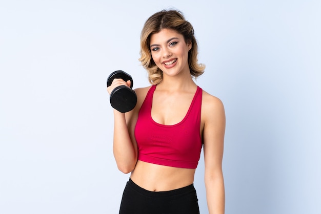 Teenager Russian girl making weightlifting isolated on blue wall thinking an idea and looking side