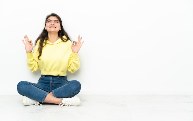 Teenager Russian girl sitting on the floor in zen pose