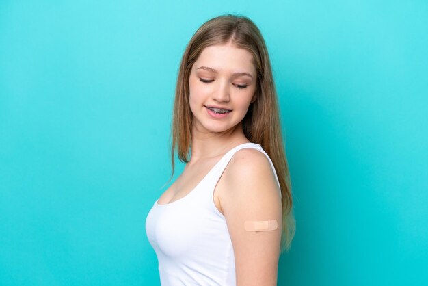 Teenager russian girl wearing a band aids isolated on blue background with happy expression