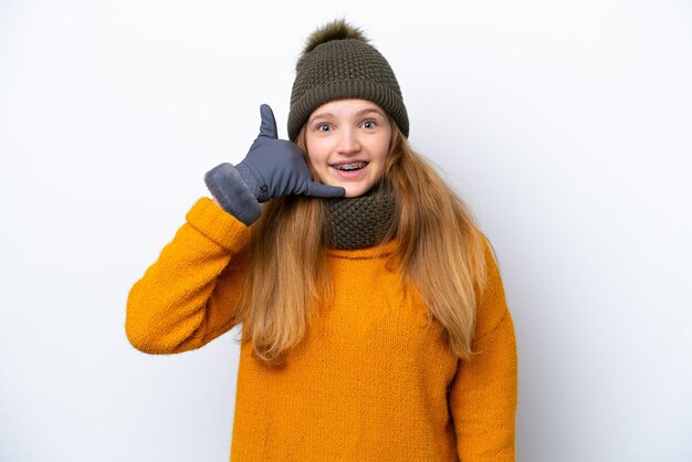 Teenager russian girl wearing winter jacket isolated on white background making phone gesture call me back sign