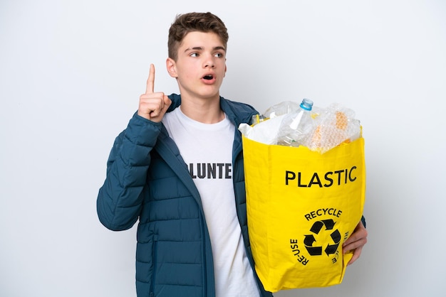 Adolescente russo che tiene un sacchetto pieno di bottiglie di plastica da riciclare su sfondo bianco pensando a un'idea che punta il dito verso l'alto