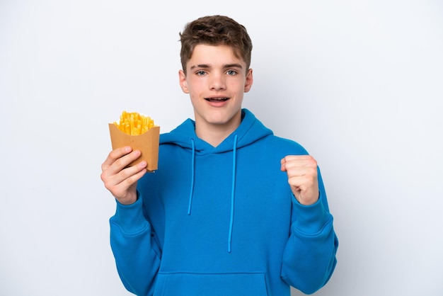 Подросток русский мужчина держит жареную картошку на белом фоне, празднуя победу в позиции победителя