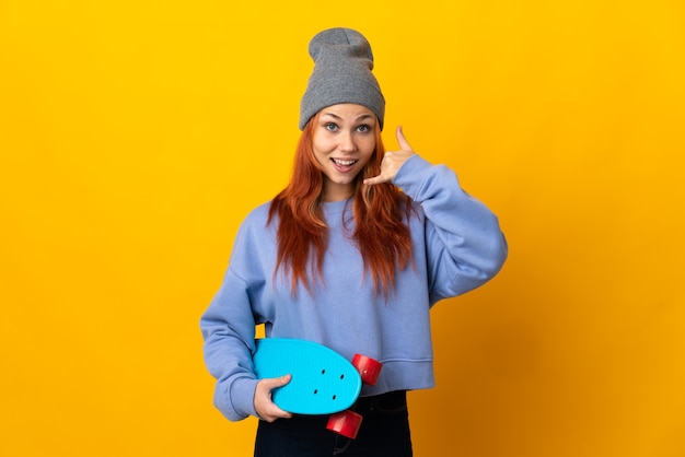 Foto ragazza russa del pattinatore dell'adolescente isolata sulla parete gialla che fa gesto del telefono. richiamami segno