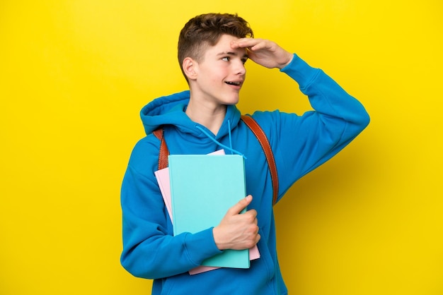 Фото Подросток русский студент мужчина изолирован на желтом фоне много улыбается