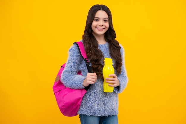 Teenager school girl with backpack holding water bottle happy teenager positive and smiling emotions of teen schoolgirl