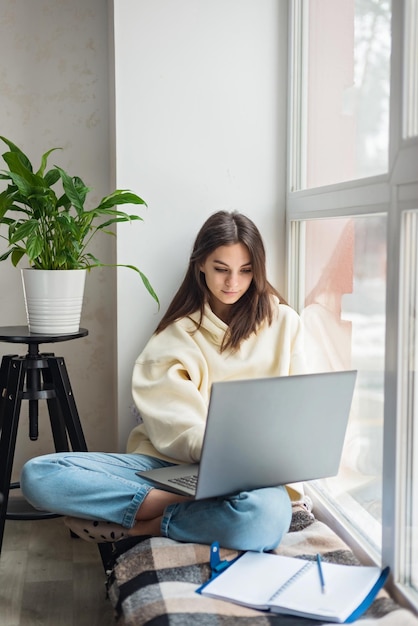 Teenager schoolgirl pupil distance learning online at remote virtual class preparing for exams watching webinar zoom meeting lesson on laptope at home Soft selective focus