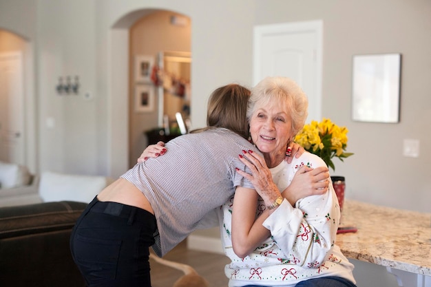 A teenager and a senior woman hugging