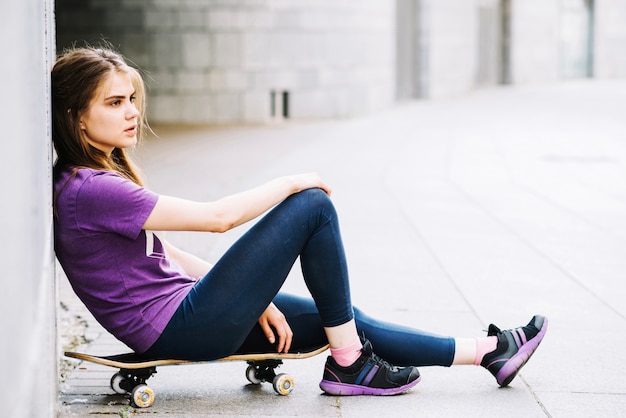 Foto adolescente su skateboard vicino alla parete