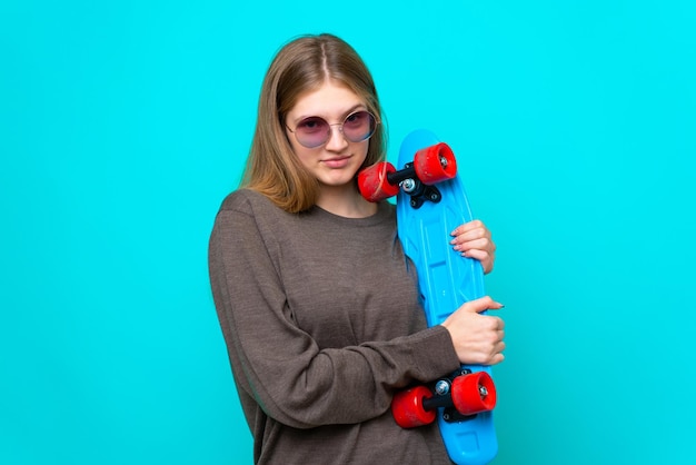 Teenager skater girl isolated on blue background