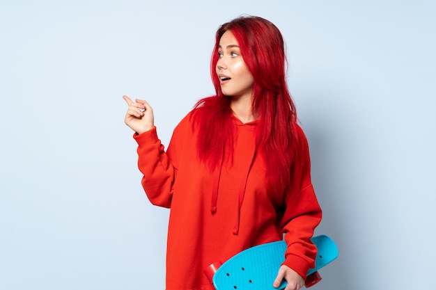 Teenager skater girl isolated on white background intending to realizes the solution while lifting a finger up