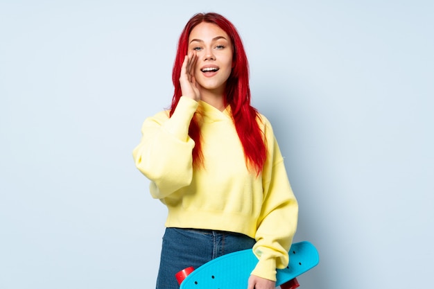 Teenager skater woman isolated on white wall shouting with mouth wide open