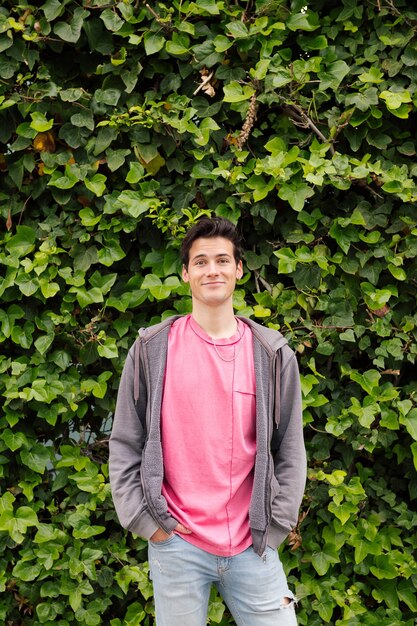 Teenager smiling on a green plants background