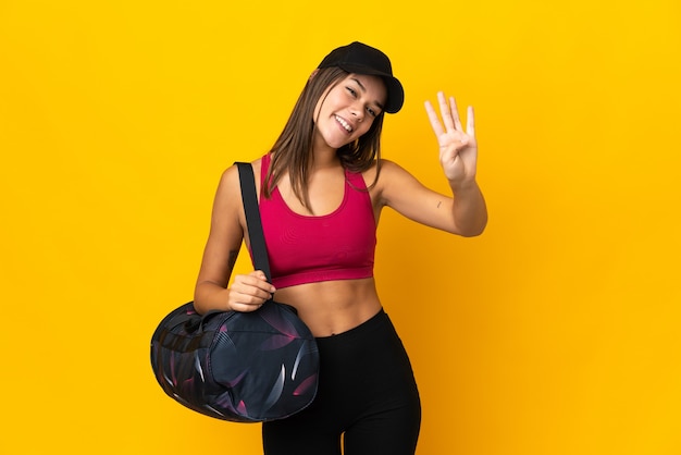 Ragazza di sport dell'adolescente con la borsa di sport felice e che conta quattro con le dita