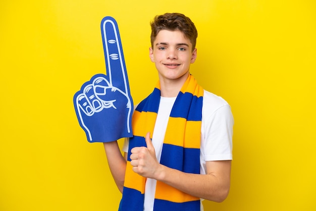 Teenager sports fan man isolated on yellow background proud and selfsatisfied