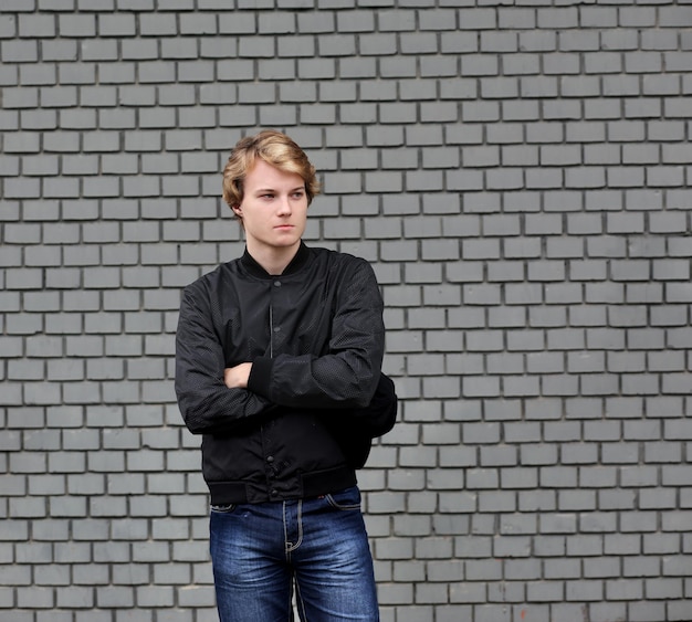 Teenager standing near a brick wall