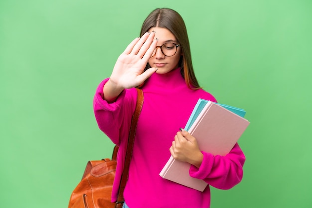 10 代の学生の白人の女の子は孤立した背景にジェスチャーを停止し、失望しました。