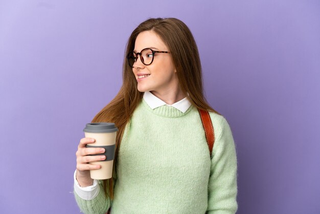 Teenager student girl over isolated purple background looking side