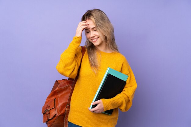 Teenager student girl on purple laughing