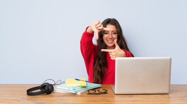 Teenager student girl studying in a table focusing face. Framing symbol