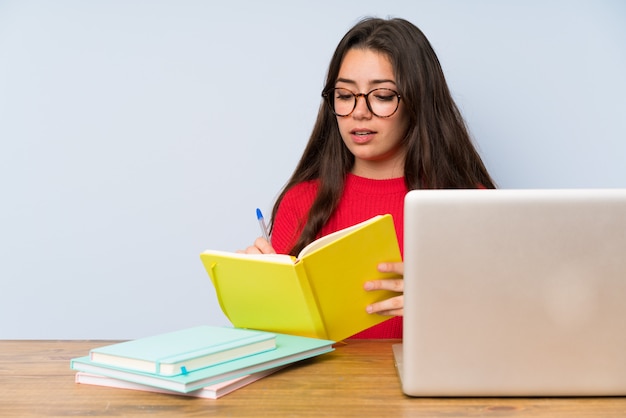 Ragazza dello studente dell'adolescente che studia in una tabella