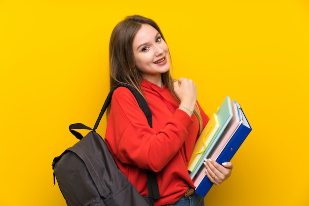 Teenager student girl over yellow