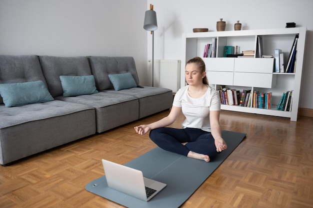 Teenager taking a virtual yoga course at home