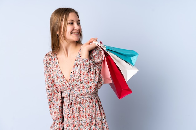 Teenager Ukrainian girl holding shopping bags and looking back