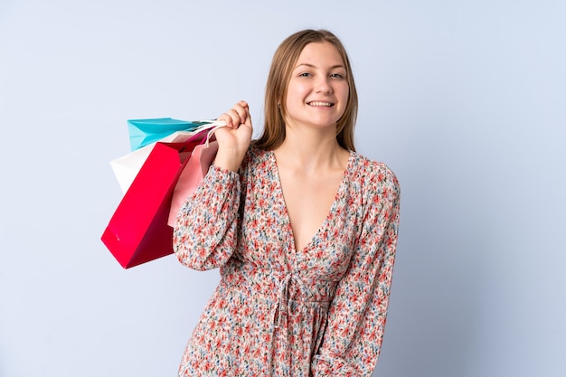 Teenager Ukrainian girl holding shopping bags and smiling