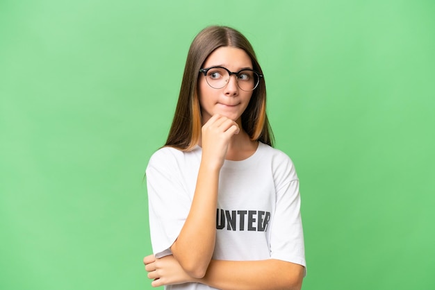 Teenager volunteer caucasian girl over isolated background having doubts and thinking