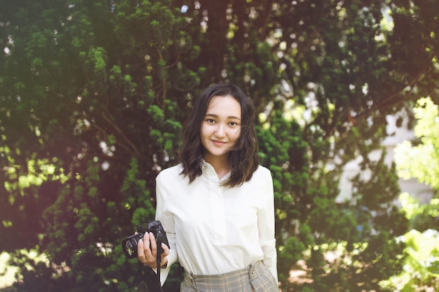 Teenager walking in the park and holding a camera