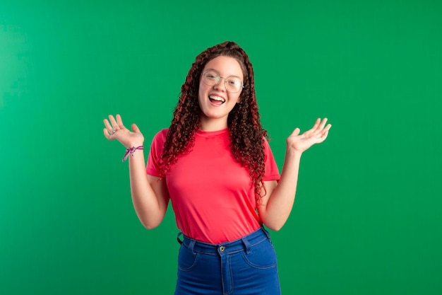 Teenager wearing glasses in fun poses in a studio photo with a green background ideal for cropping