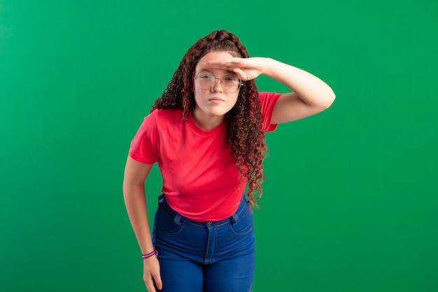 Teenager wearing glasses in fun poses in a studio photo with a green background ideal for cropping