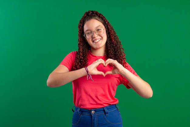 Teenager wearing glasses in fun poses in a studio photo with a green background ideal for cropping