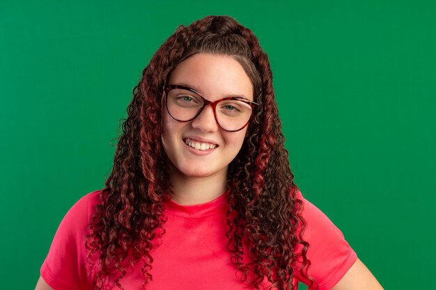 Photo teenager wearing glasses in fun poses in a studio photo with a green background ideal for cropping