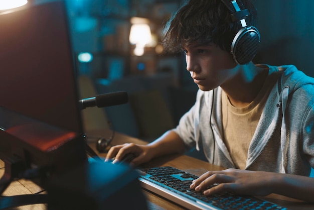 Teenager Boy Online Plays A Computer Game With Headphones And A