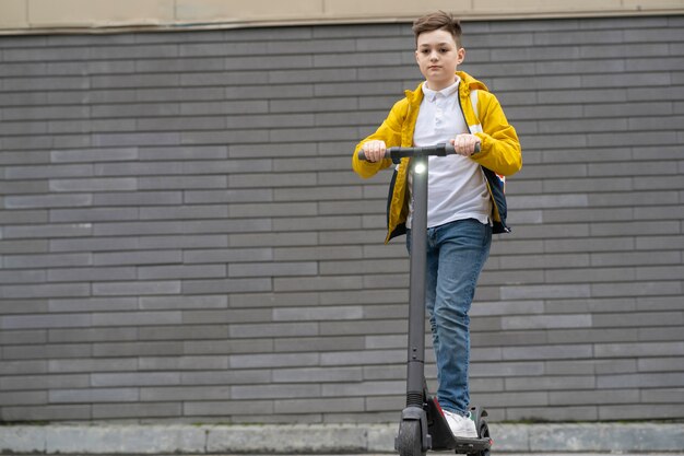 Teenager with backpack rides on electric scooter