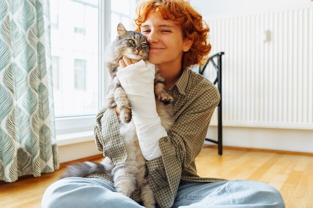 Teenager with broken arm in cast and pet cat