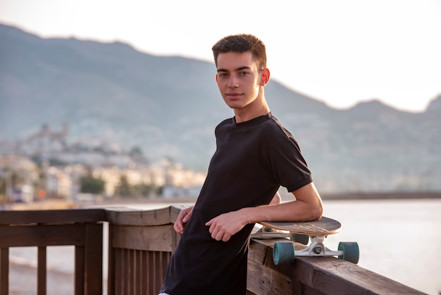 Teenager with his long board in promenade