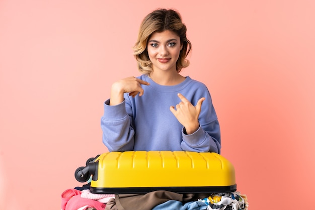 Teenager woman with salad isolated on blue pointing to oneself