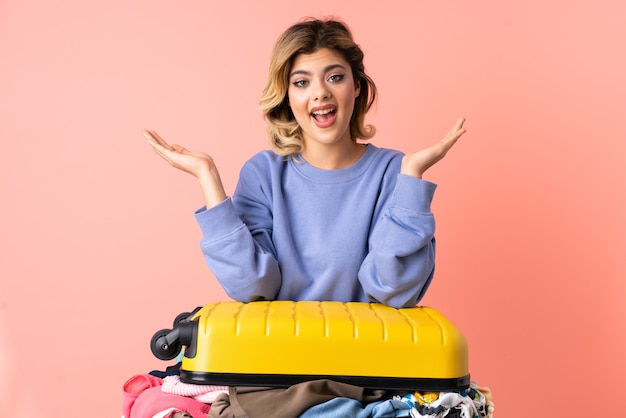 Teenager woman with salad isolated on blue wall with shocked facial expression