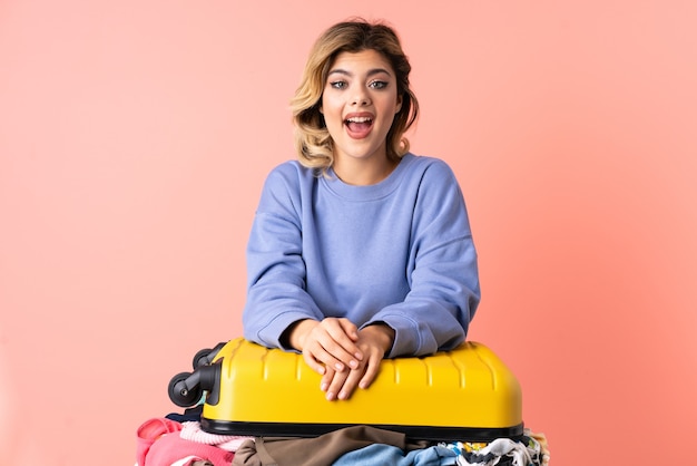 Teenager woman with salad isolated on pink with surprise facial expression