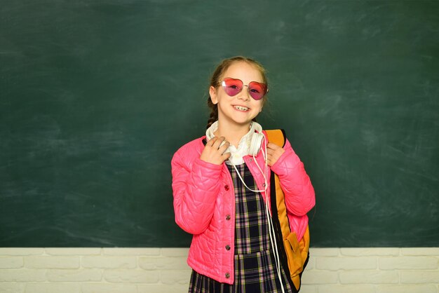 Photo teenager younf school girl with backpack. portrait of a teen female student. funny school girl wearing eyeglasses. education concept. young teenager schoolgirl with school backpack and headphone.