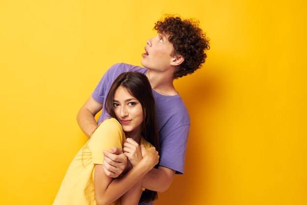 Teenagers in colorful tshirts posing friendship fun yellow background unaltered