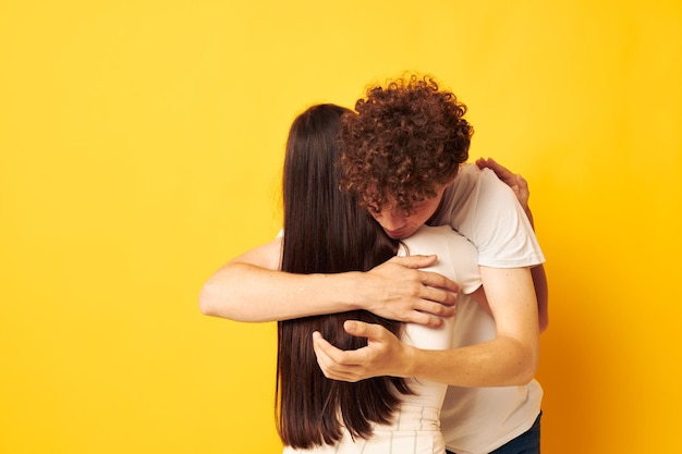 Photo teenagers hug friendship relationship fun yellow background unaltered