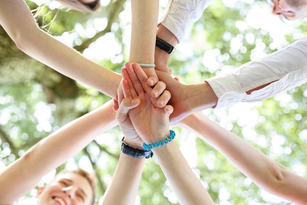 Teenagers joined their hands in a circle